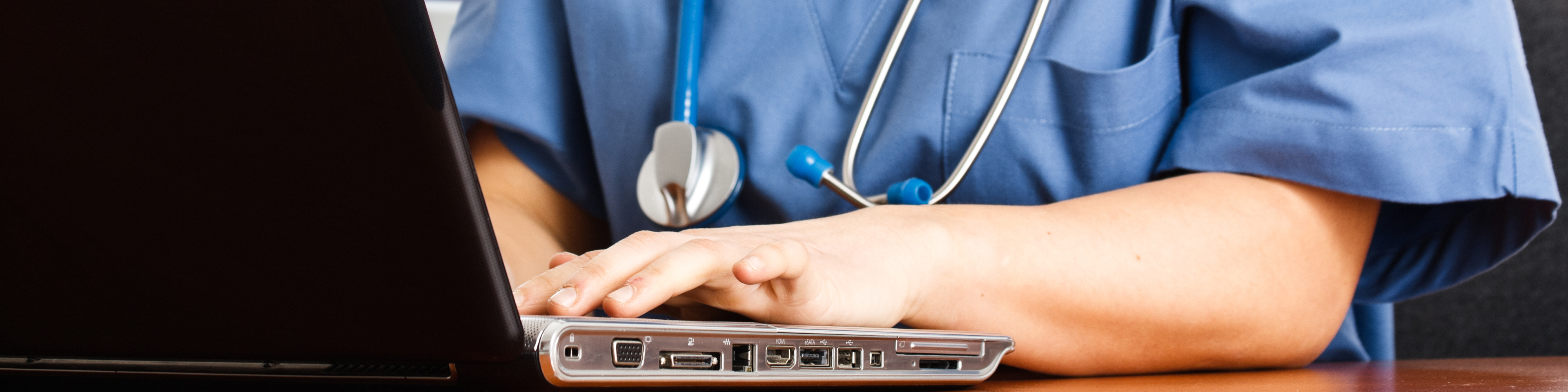 Healthcare worker sitting at laptop researching