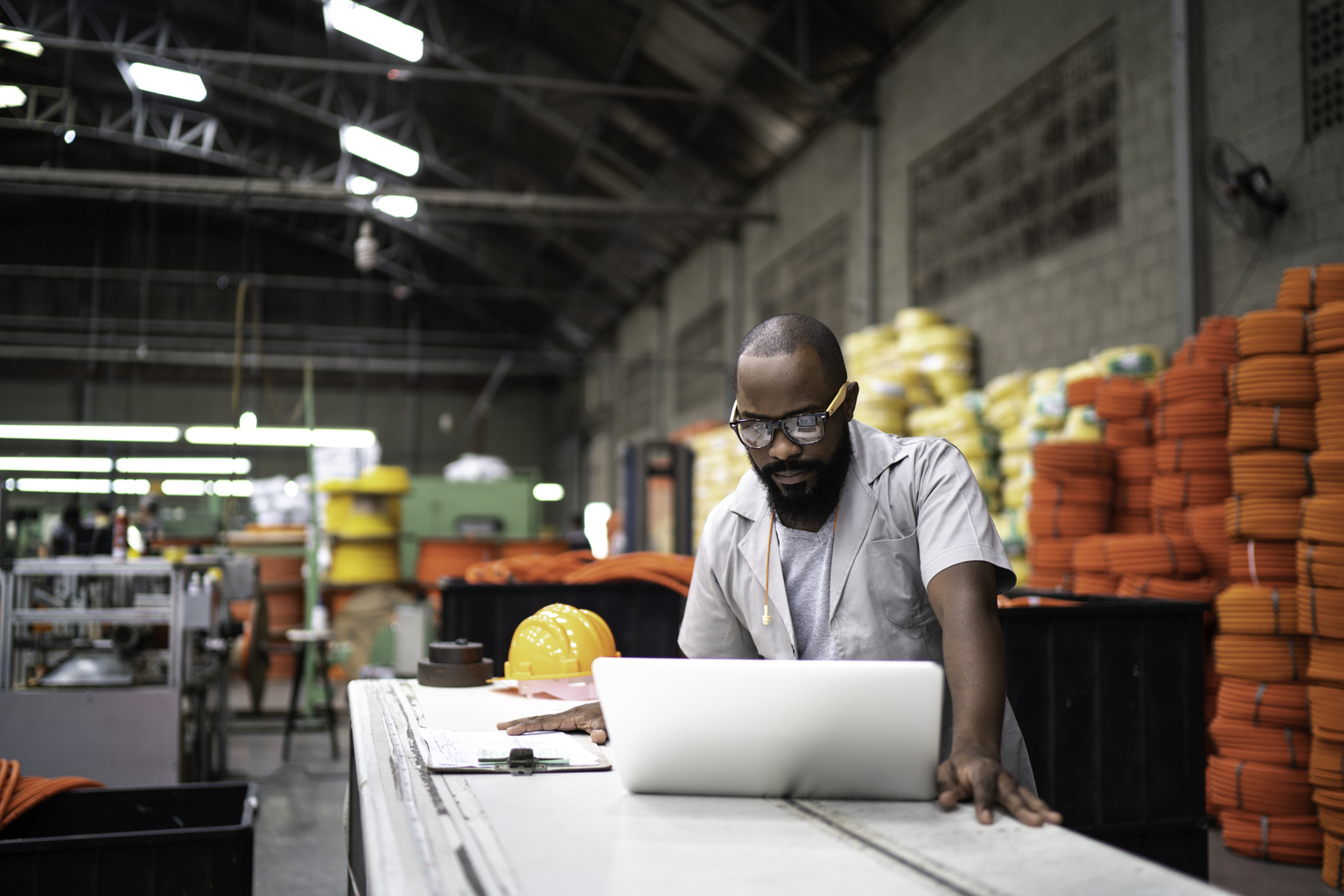 Man on laptop in a factory