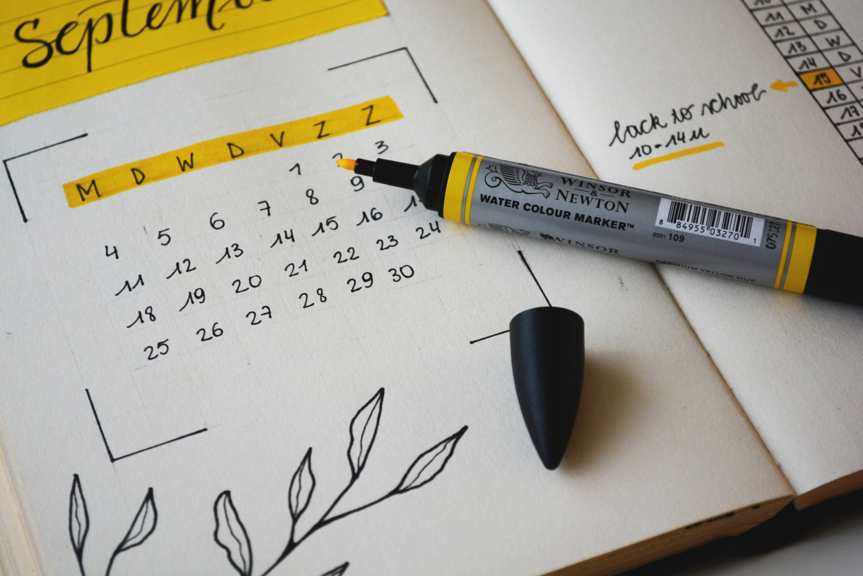 Monthly planner open to September with yellow highlighter sitting open on top