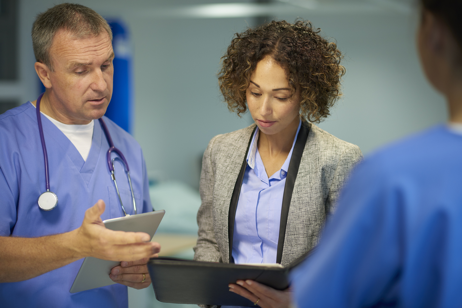 Mature white male doctor meets with businesswoman.