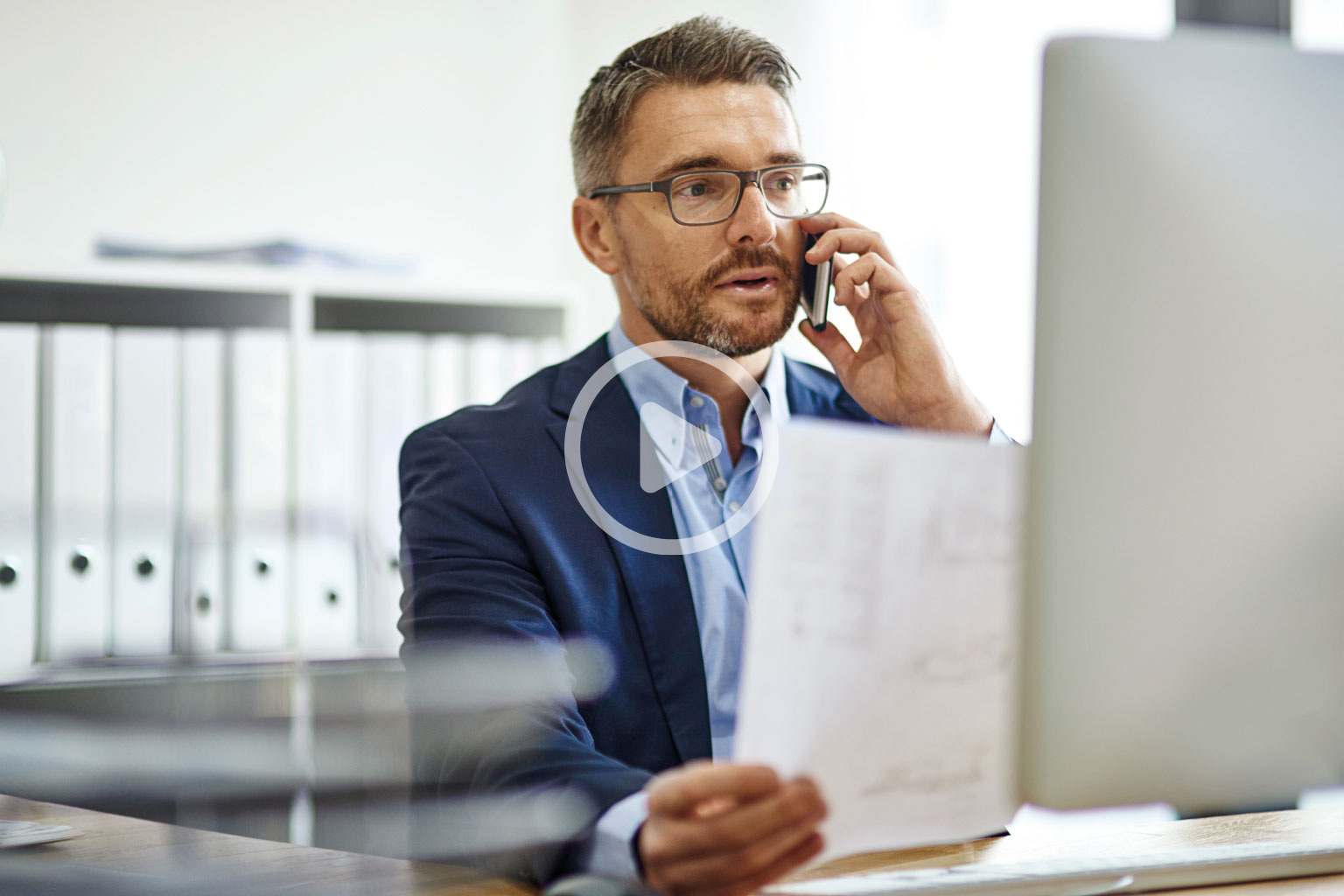 Dyrektor szpitala rozmawia przez telefon patrząc na system LEX Medica, który ma na laptopie