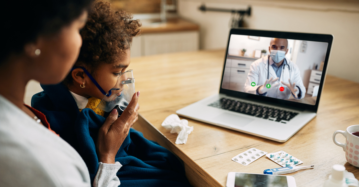 Black pediatrician talking via video call to the mother who is giving her daughter inhaling therapy at home