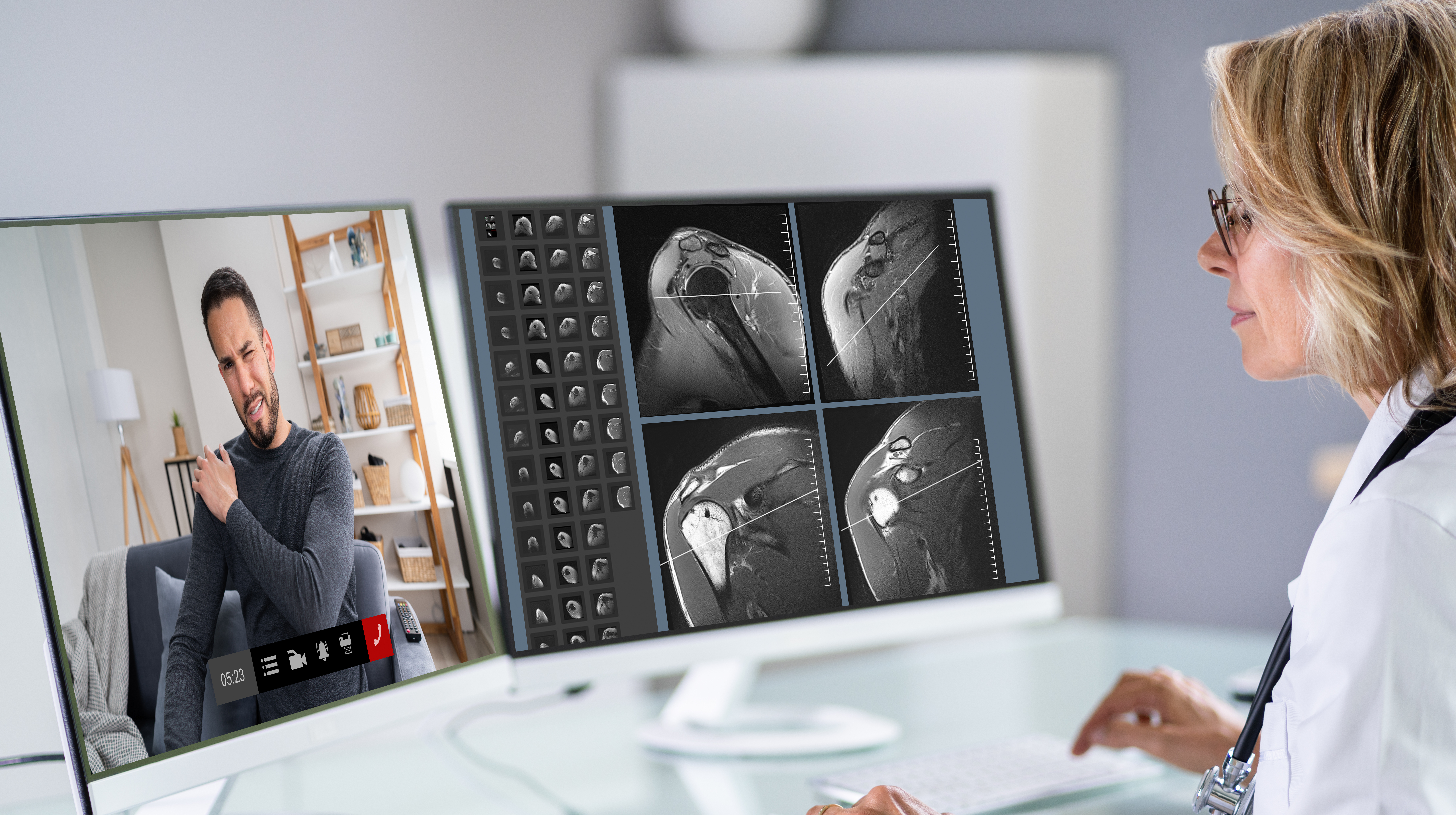 Physician looking at computer screens for online video conference, telehealth, with patient