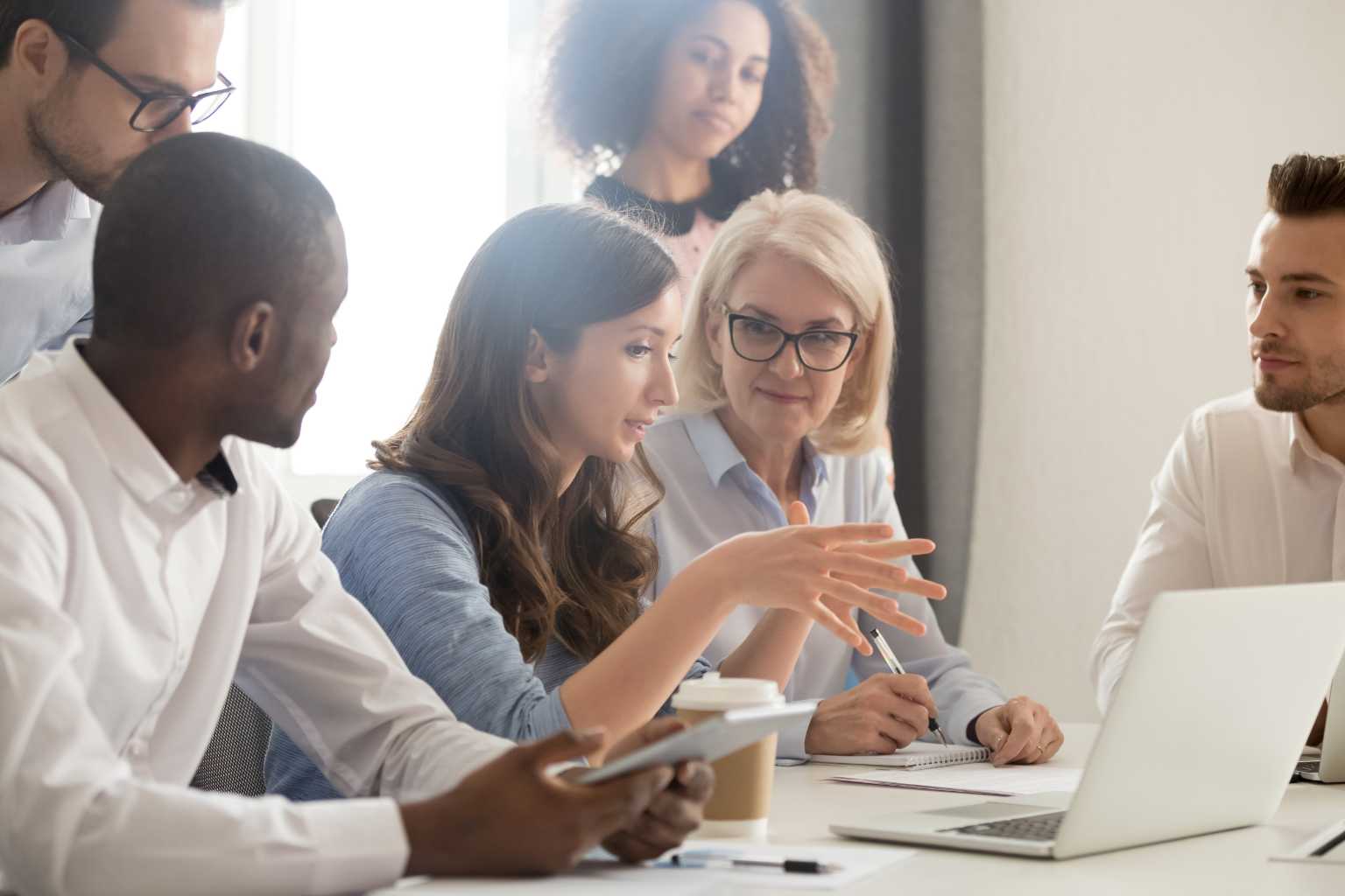 Group gathers around laptop