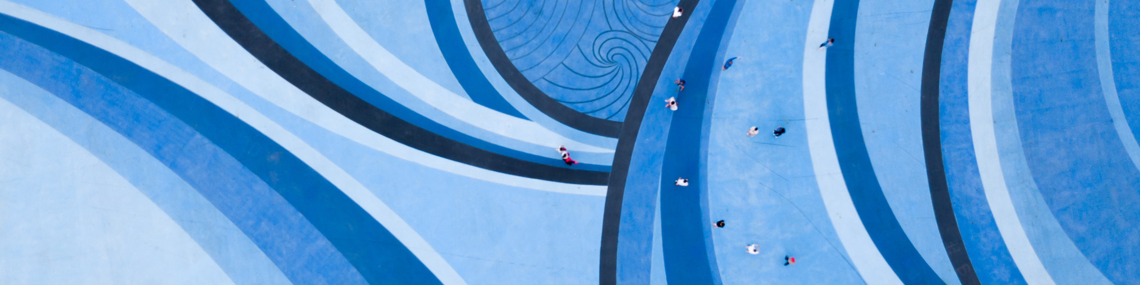 Aerial Drone View of People walking over a Circular Swirl Patterned Blue Floor