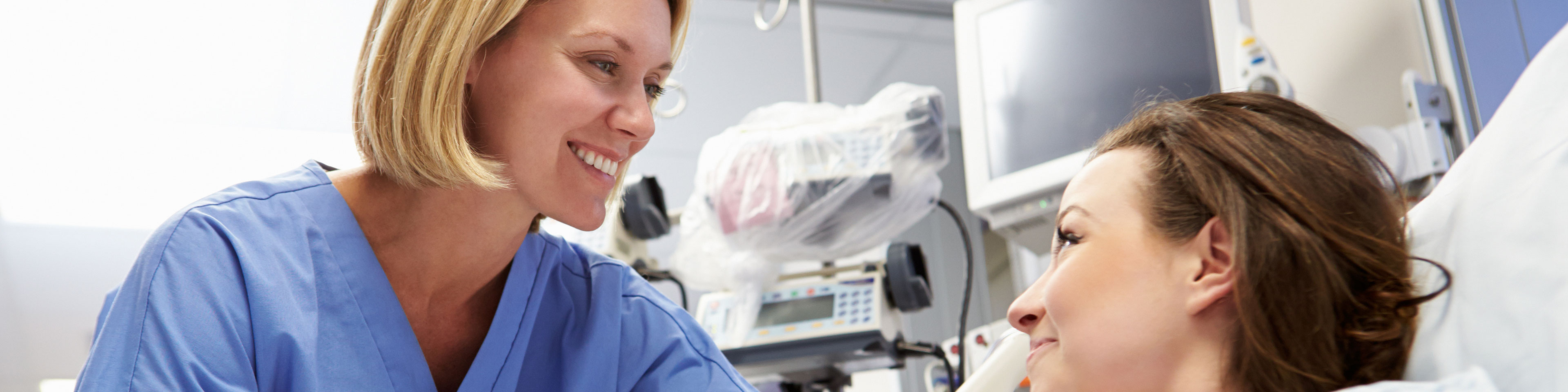 nurse bedside smiling at patient