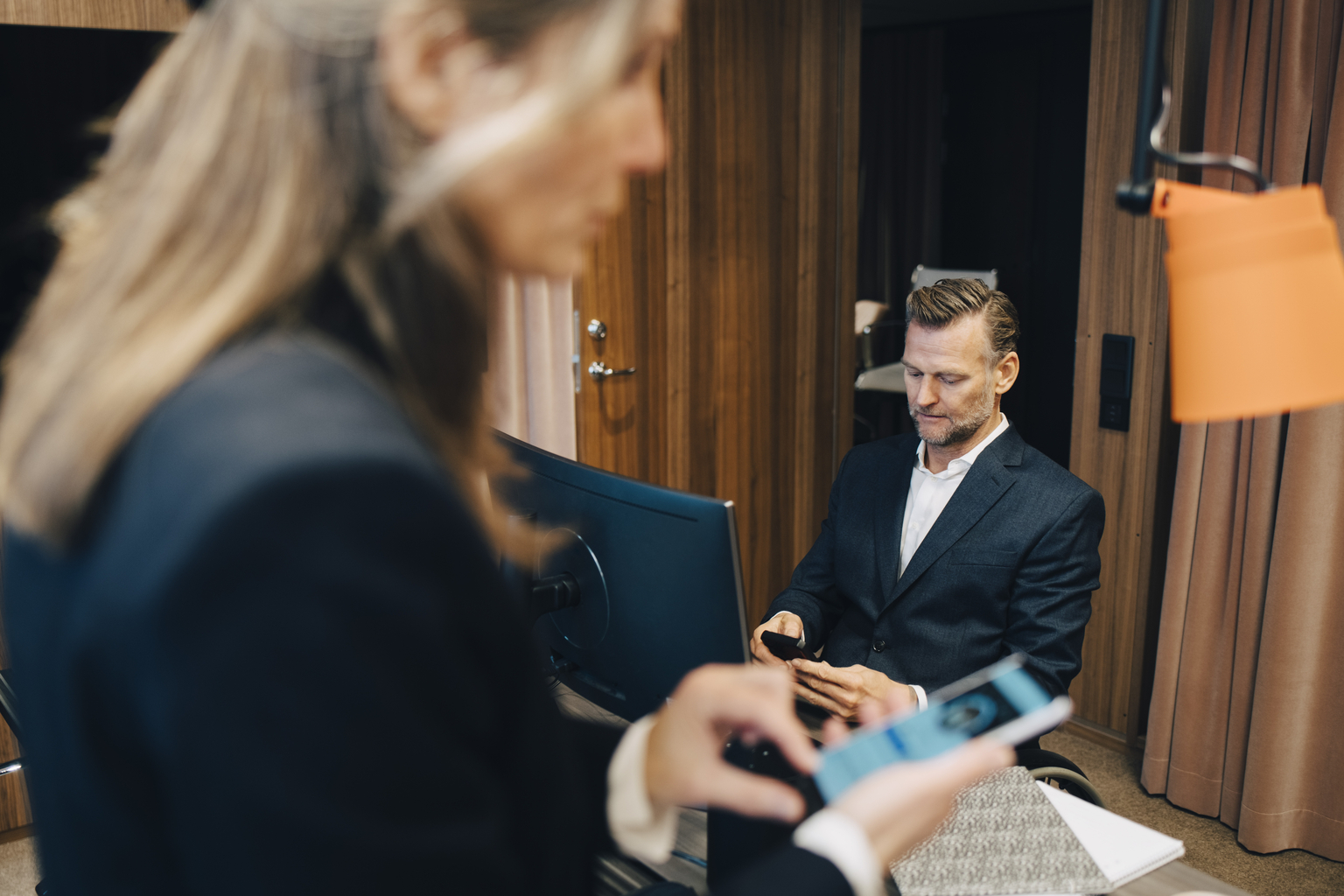 Business people using smart phones in office