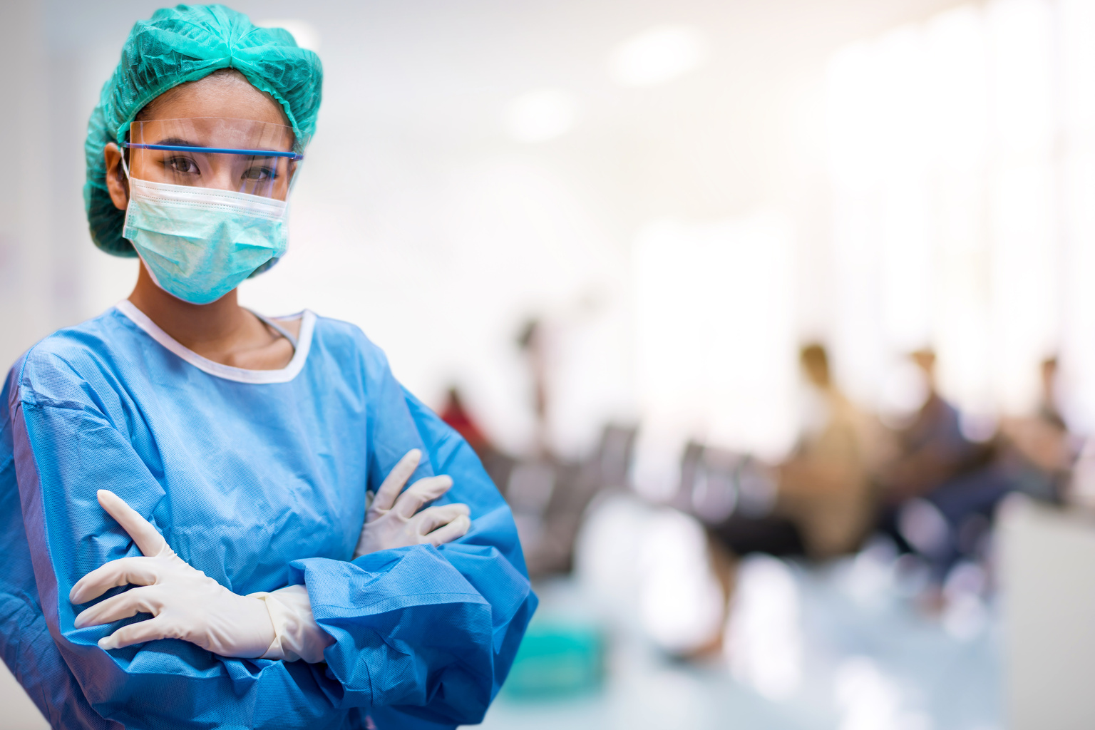 Confident medical professional woman in scrubs and COVID-19 mask