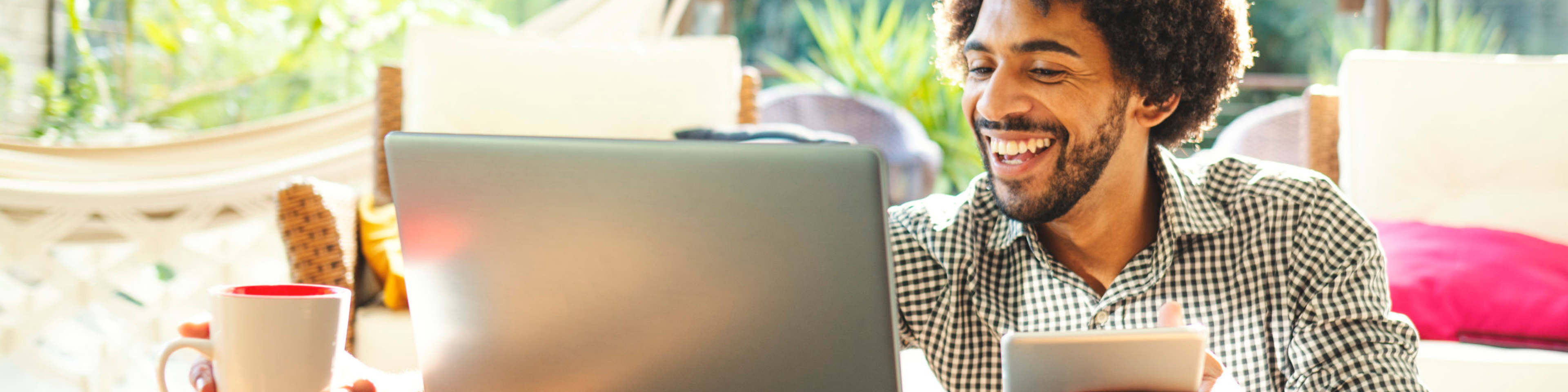 man in casual clothes wearing orange socks with airpods in watching laptop screen