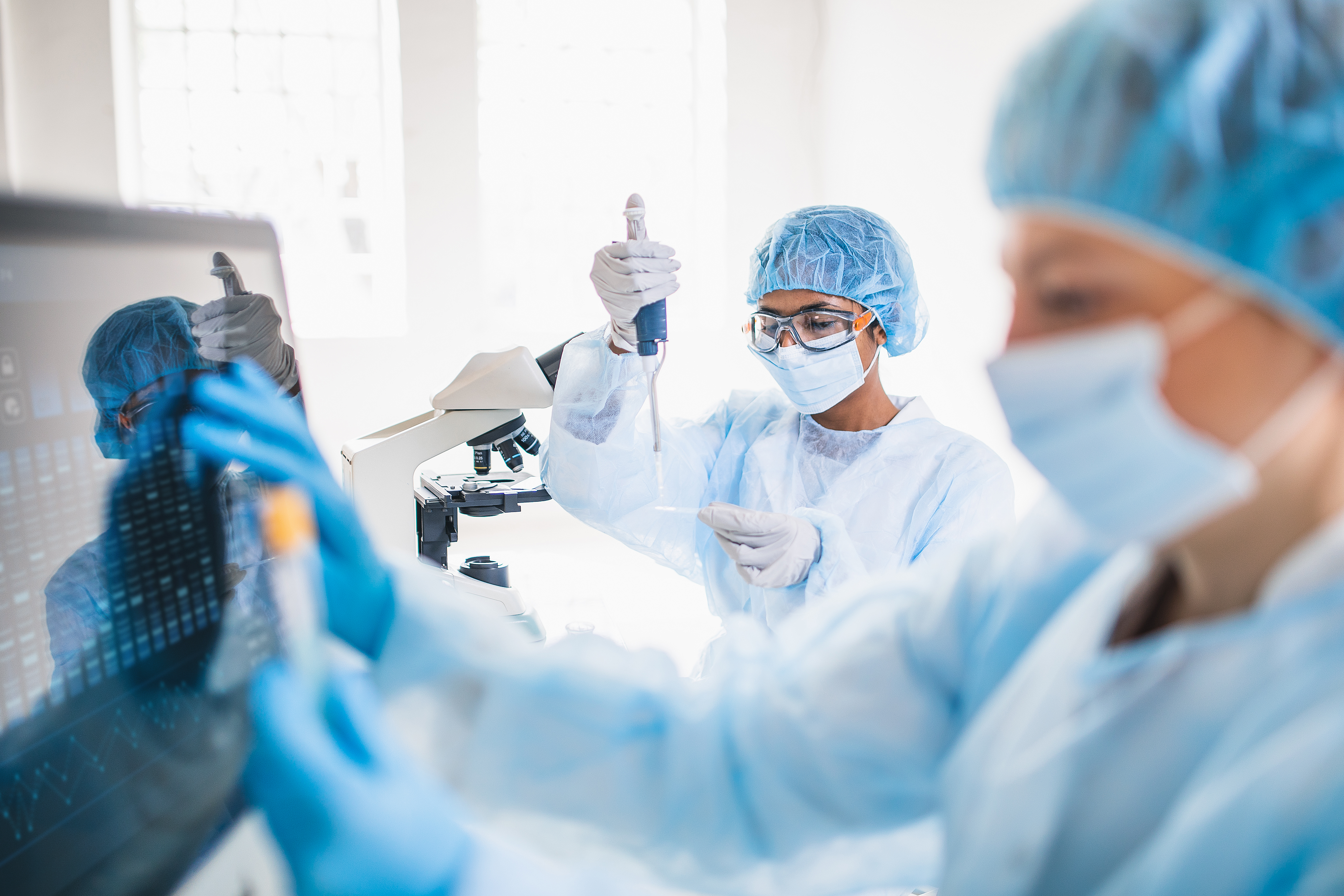 Female scientists wearing full protective suit working in the laboratory.