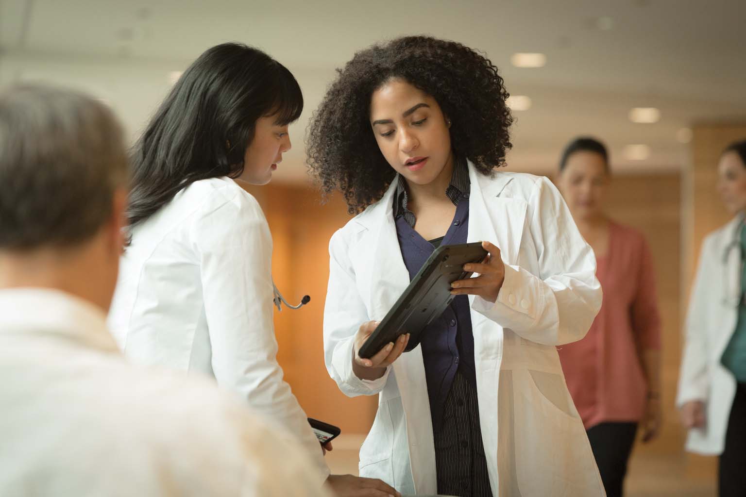 two doctors discussing information displayed on a tablet