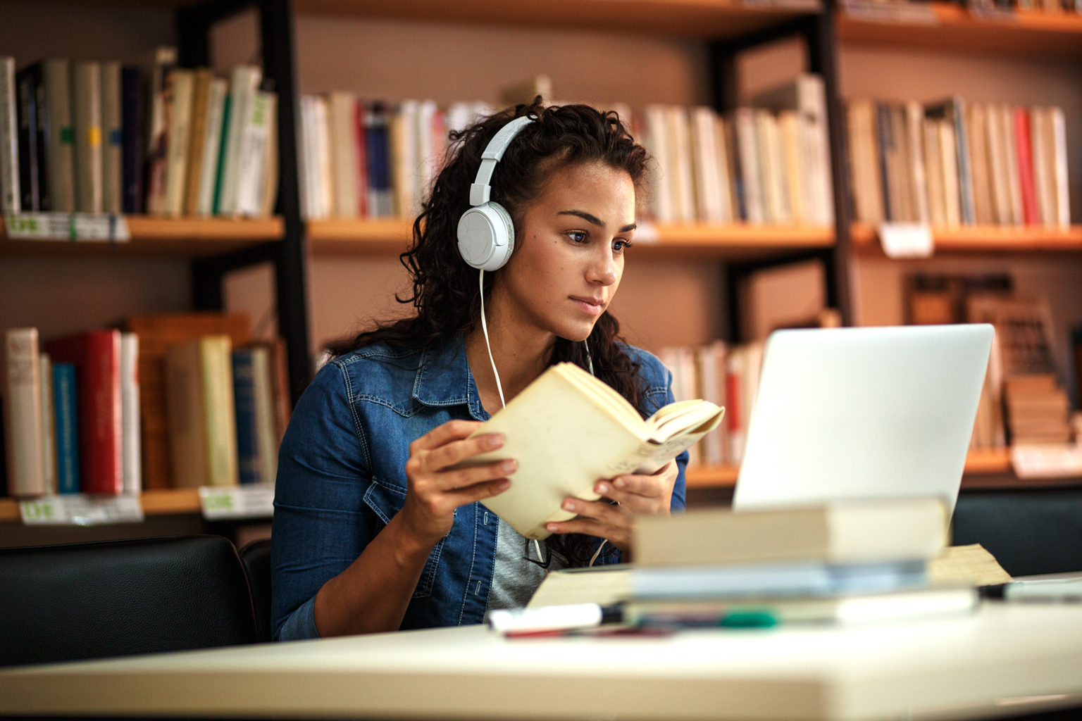 Young female student study in the school library using laptop