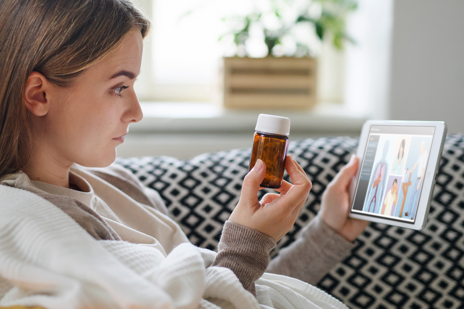 Young woman researching something about her pill bottle on Emmi on her tablet