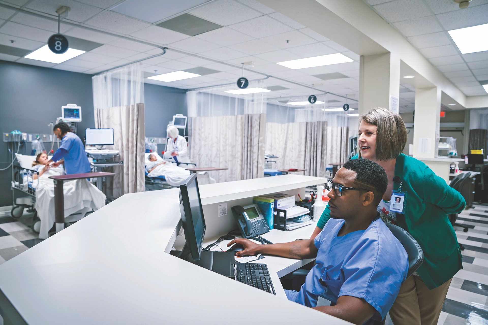 Nurses reviewing information on computer at nurses' station