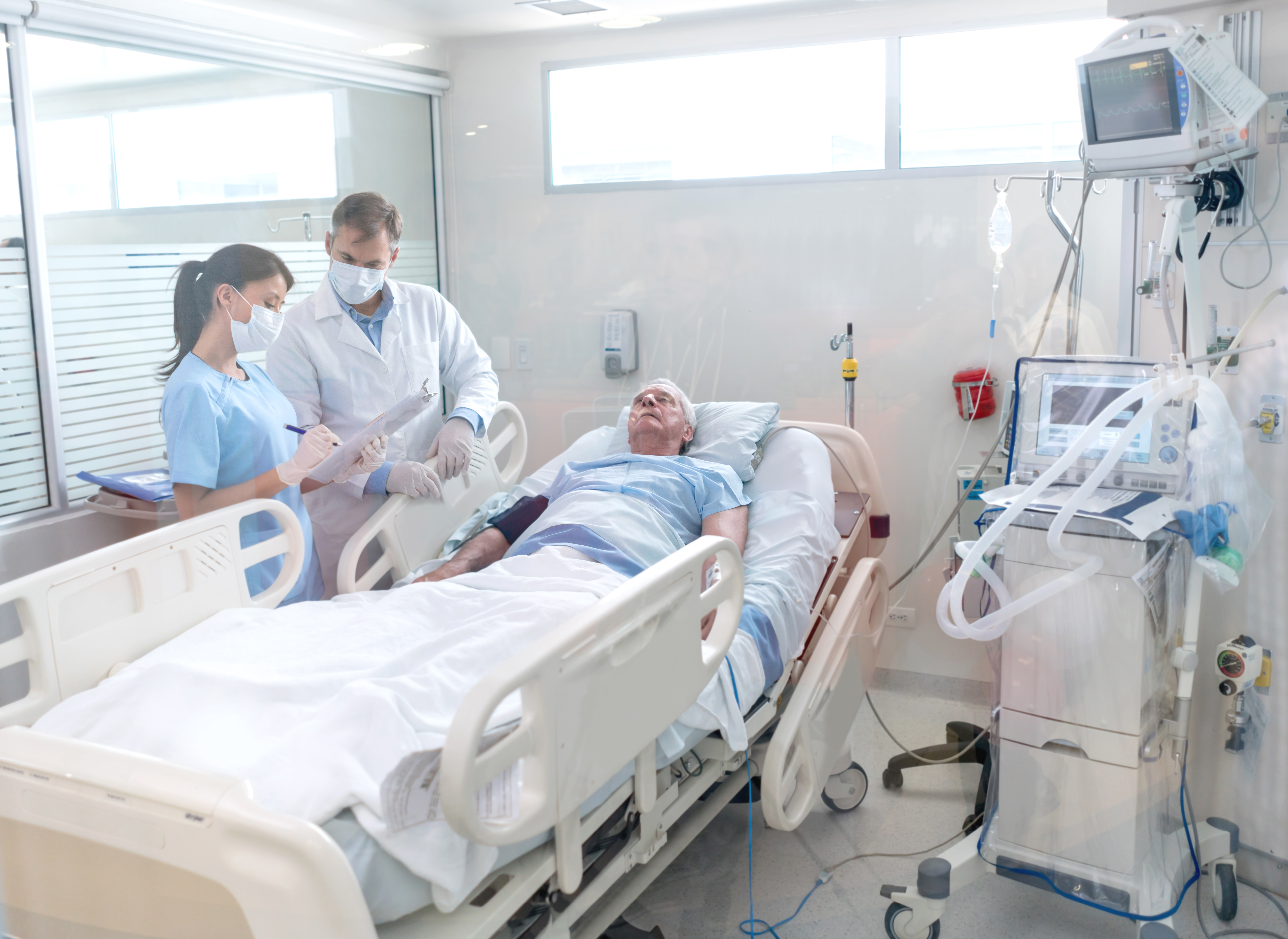 Doctors working at the hospital and checking on a senior patient at the Intensive Care Unit.