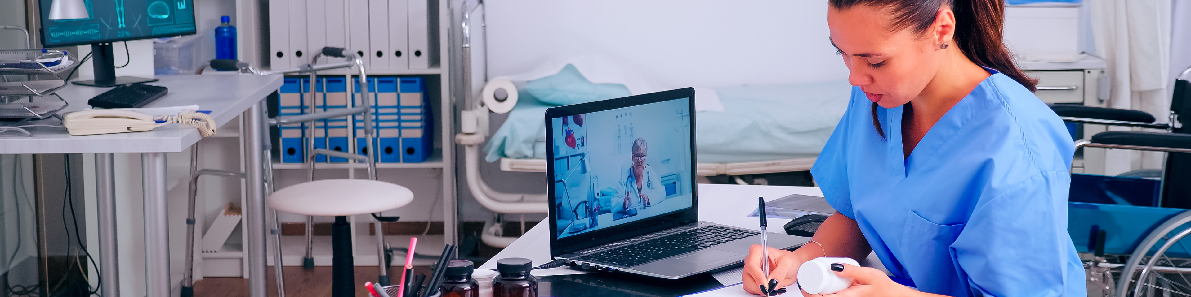 Nurse taking notes listening to remote doctor during video call
