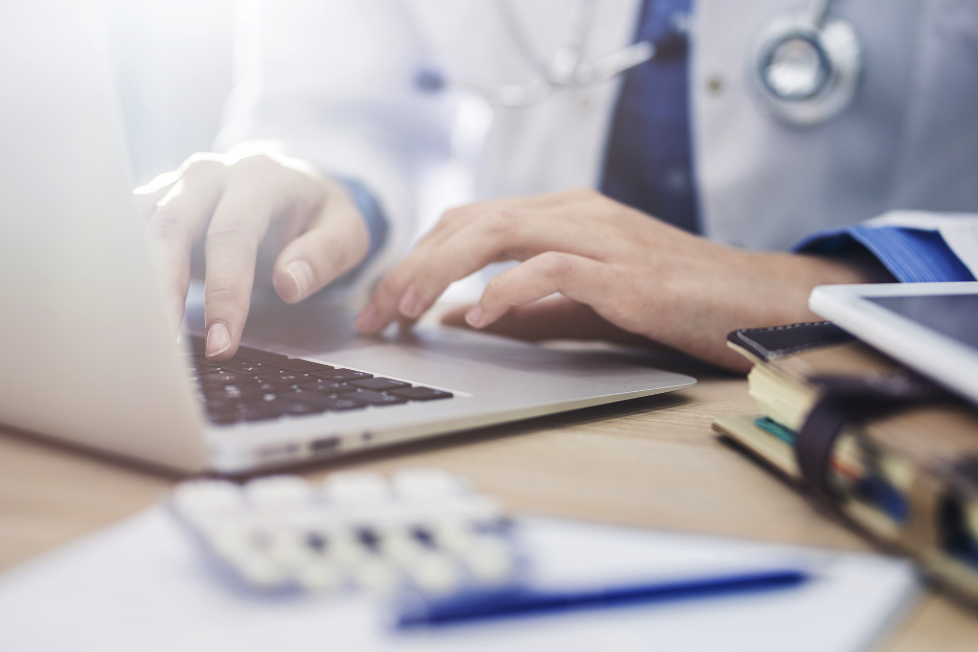 Close up on doctor typing at laptop computer