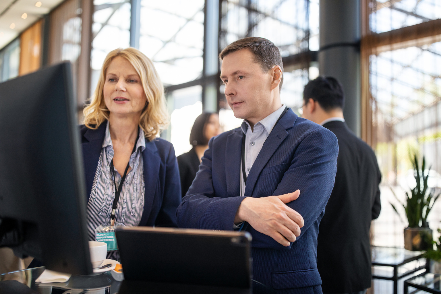 Executive explaining her ideas to businessman in auditorium