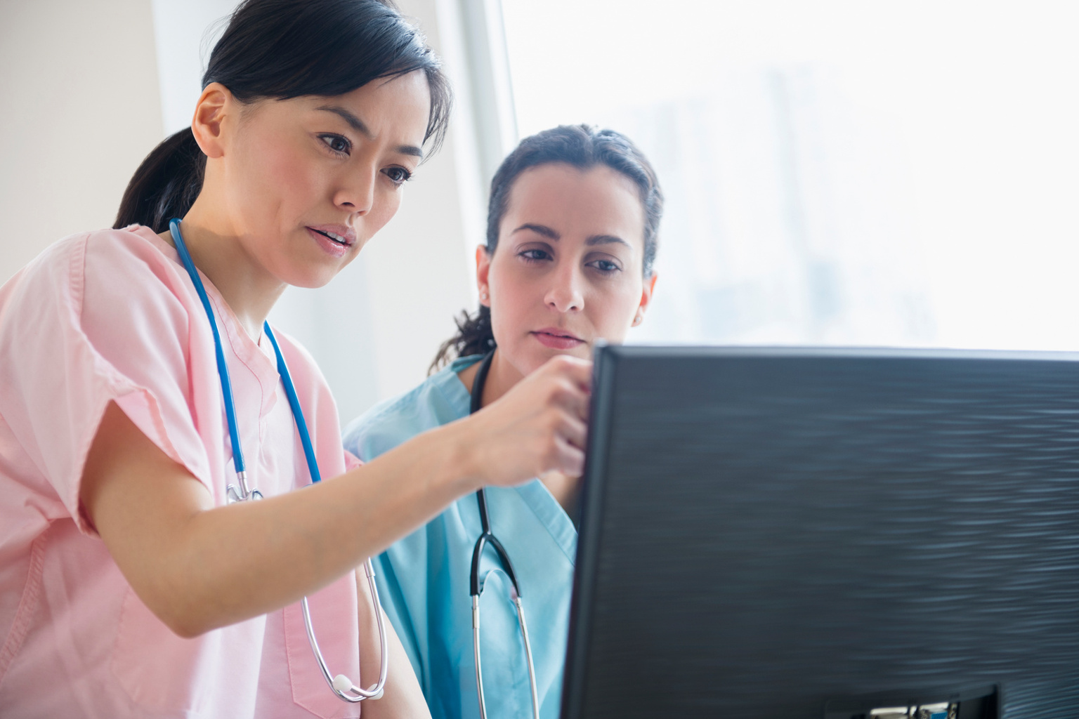 Experienced nurse reviewing patient record with new nurse