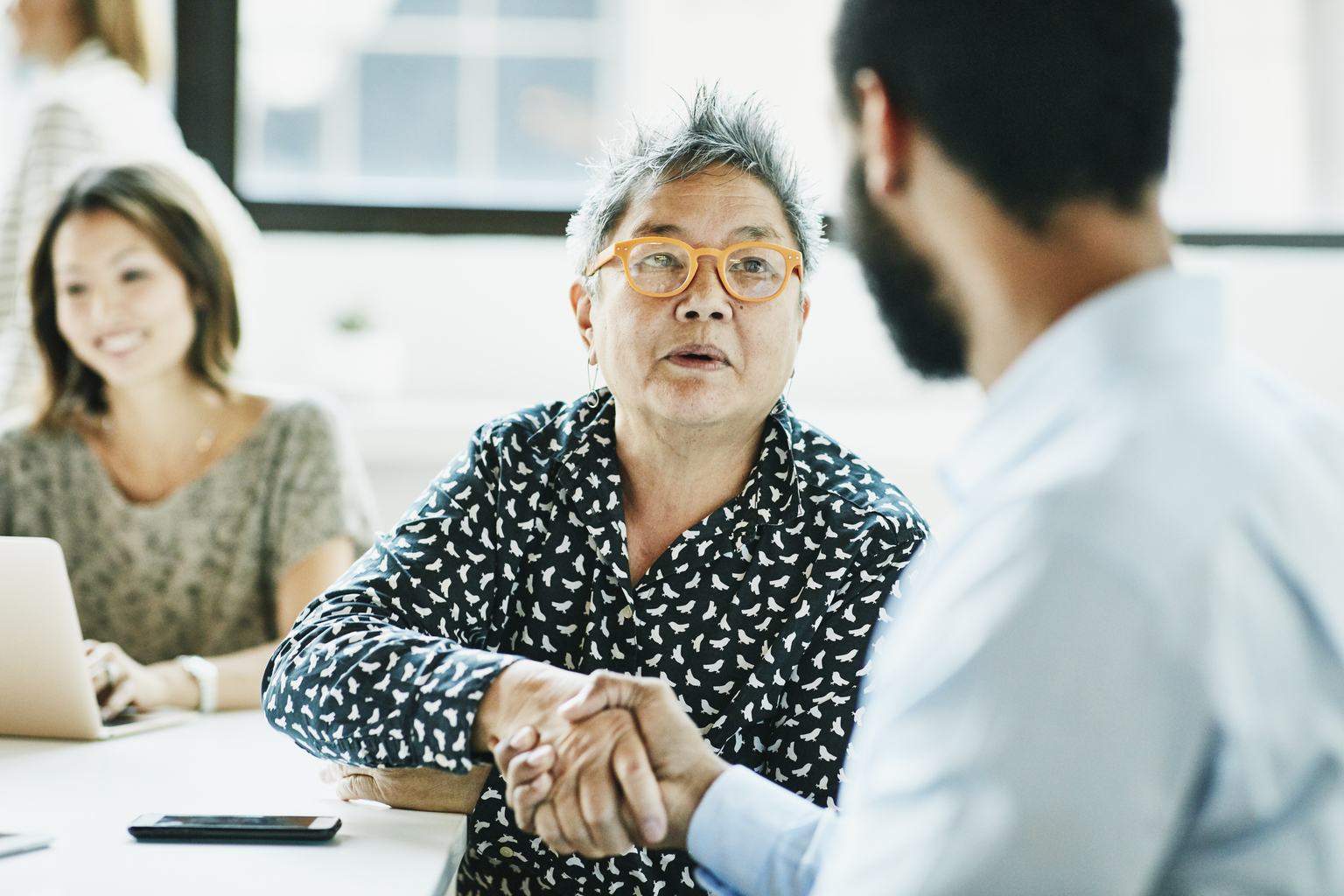 Senior businesswoman shaking hands with client after meeting in office