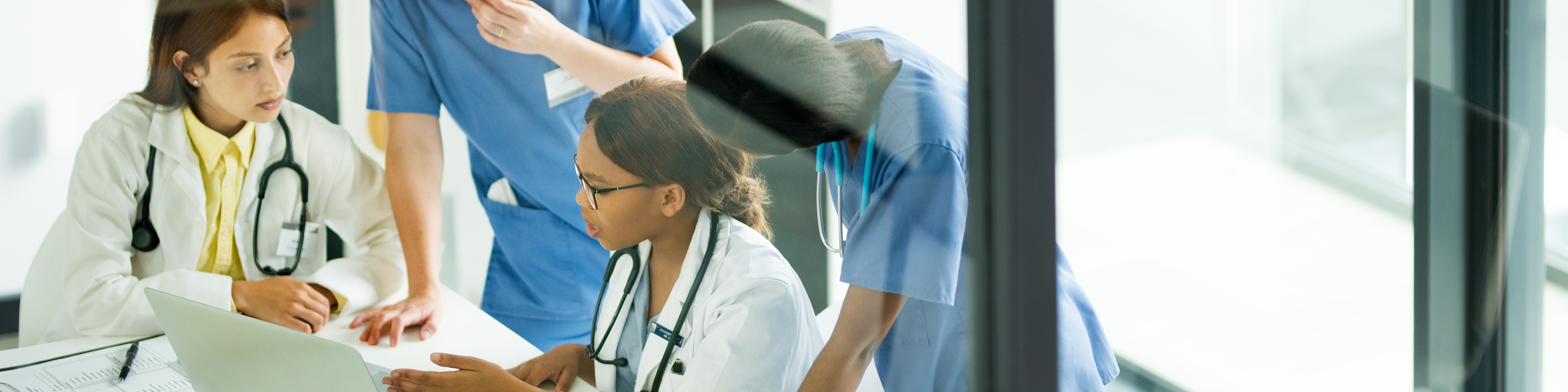 Group of medical practitioners working together on a laptop