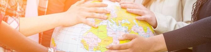Diverse hands on globe of world