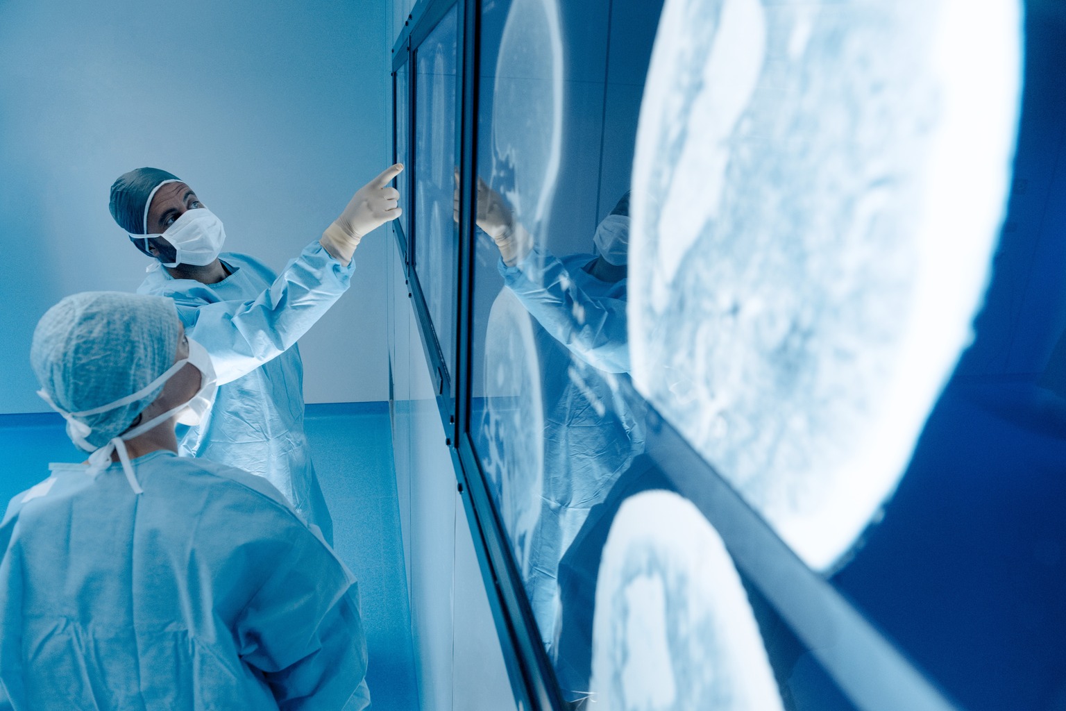 Surgeons looking at magnetic resonance imaging (MRI) brain scans during brain surgery