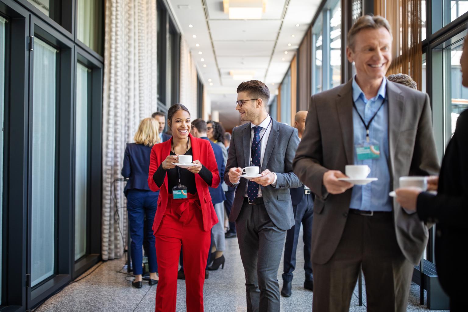 Shot of cheerful business people walking together with coffee during a break in seminar event