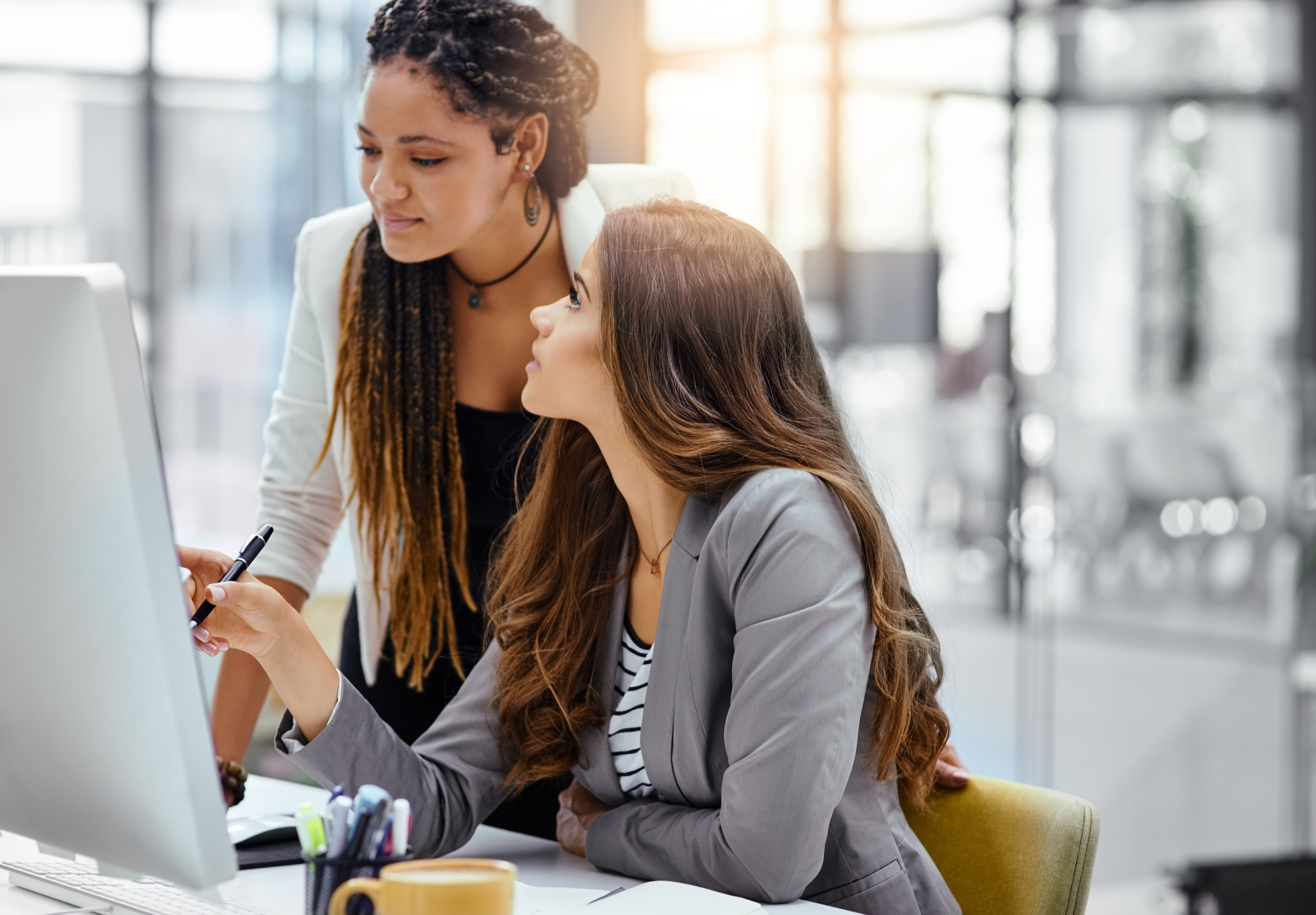 Two women in conversation looking at a computer monitor