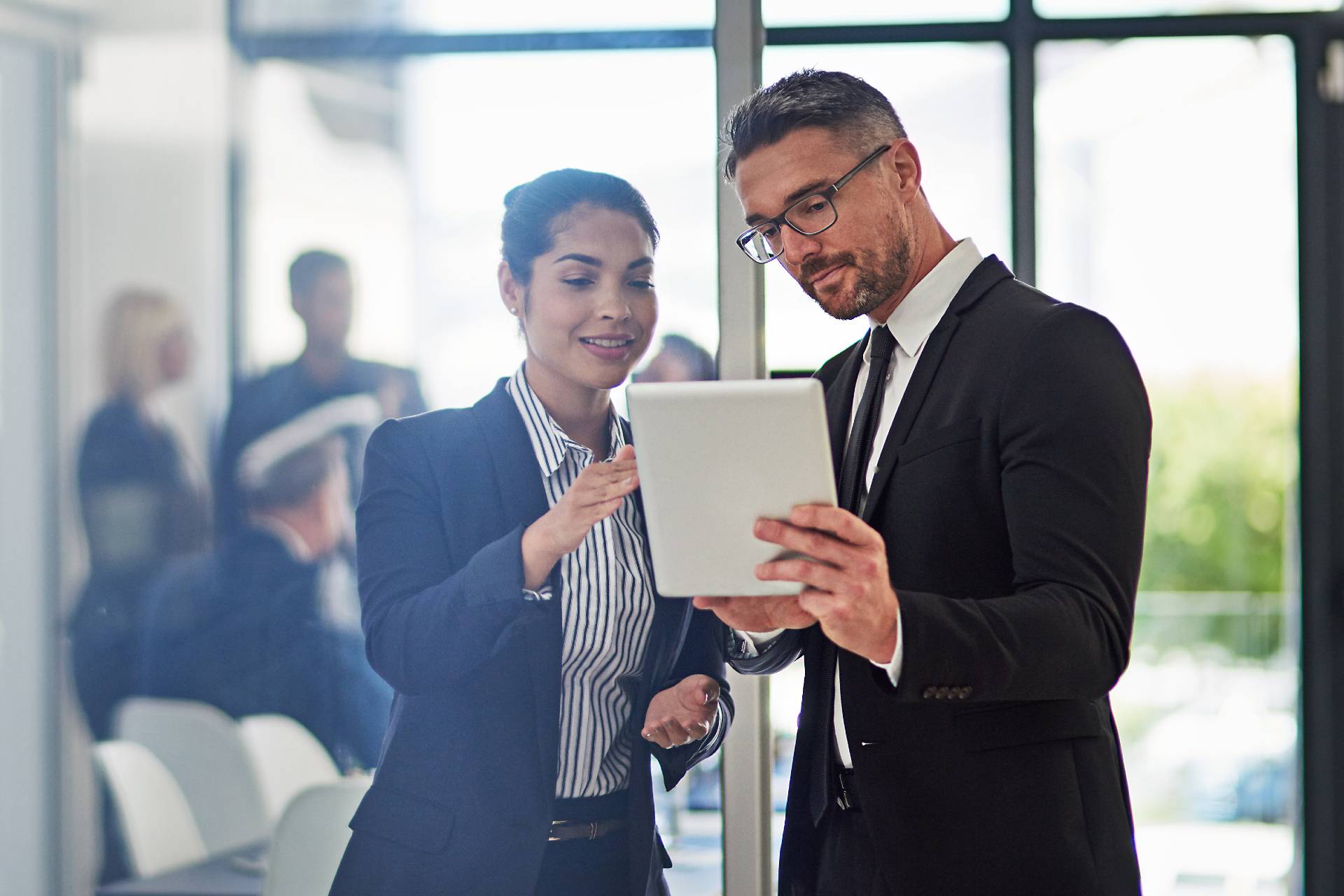 man and woman looking at an ipad