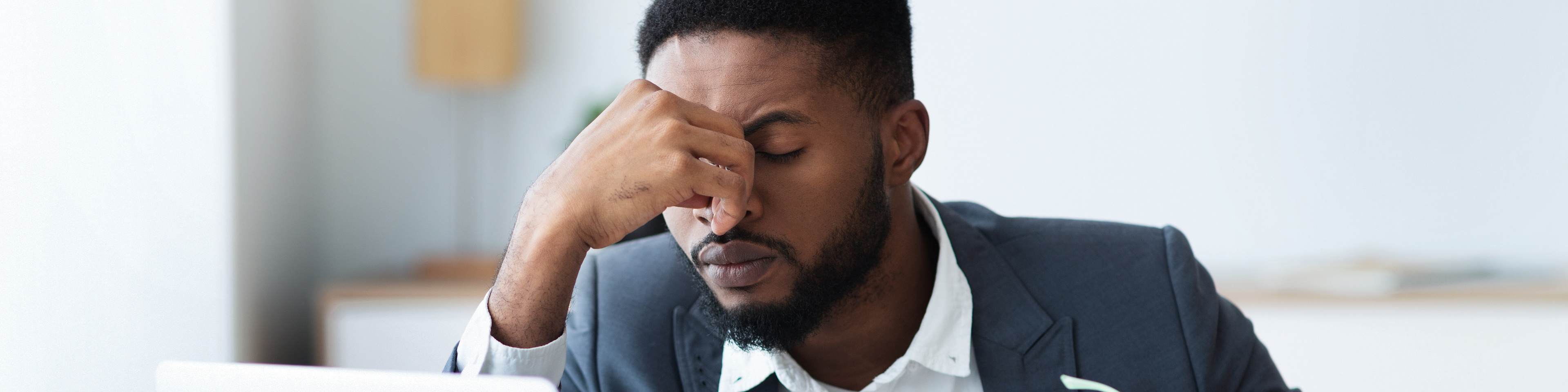 Businessman sitting at his laptop looking stressed