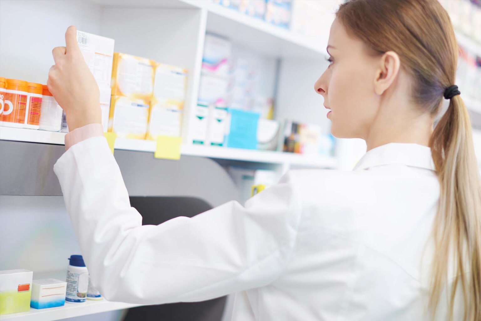 pharmacist examining medication in pharmacy