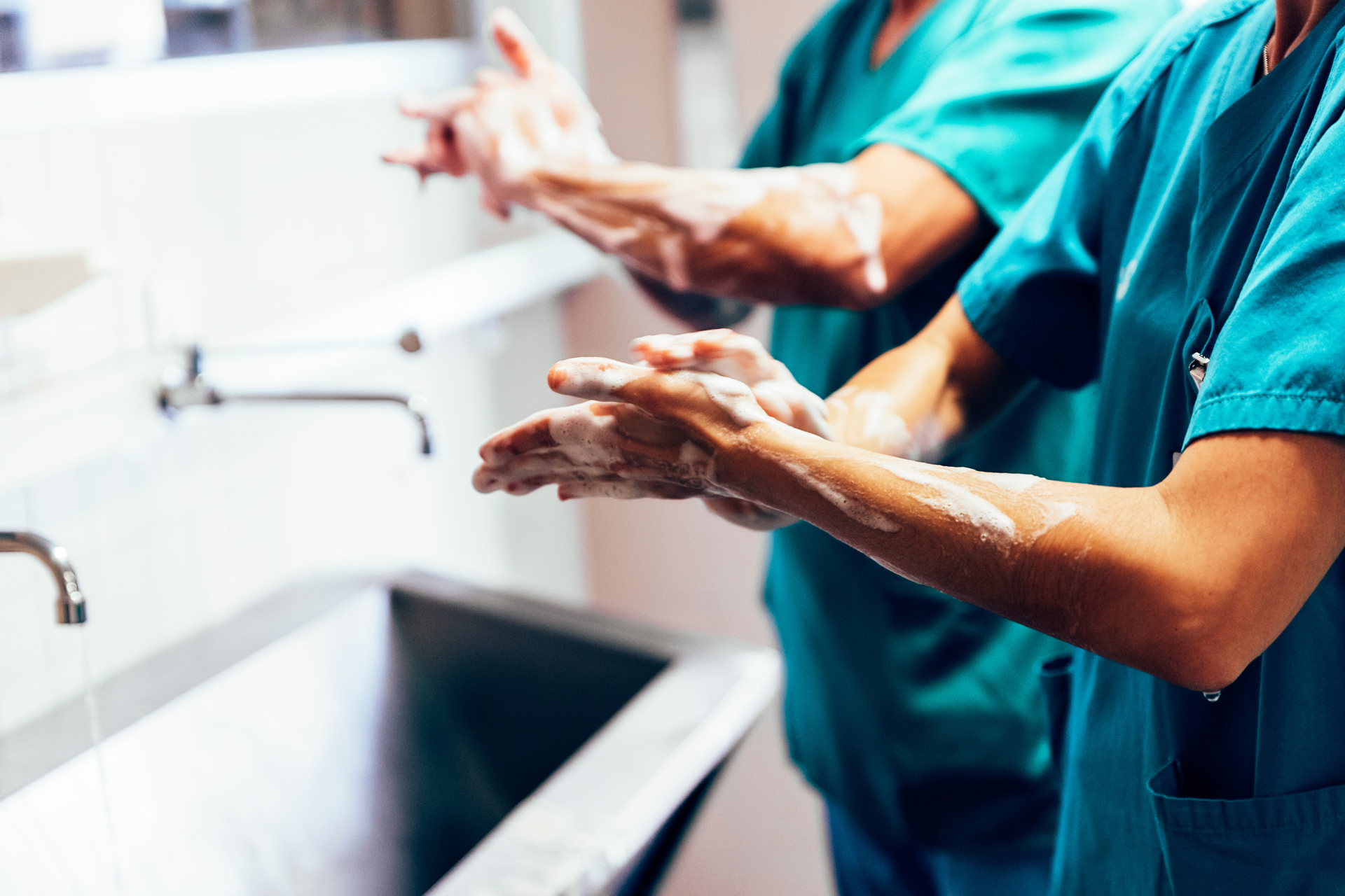 Surgeons scrubbing hands and arms before a procedure