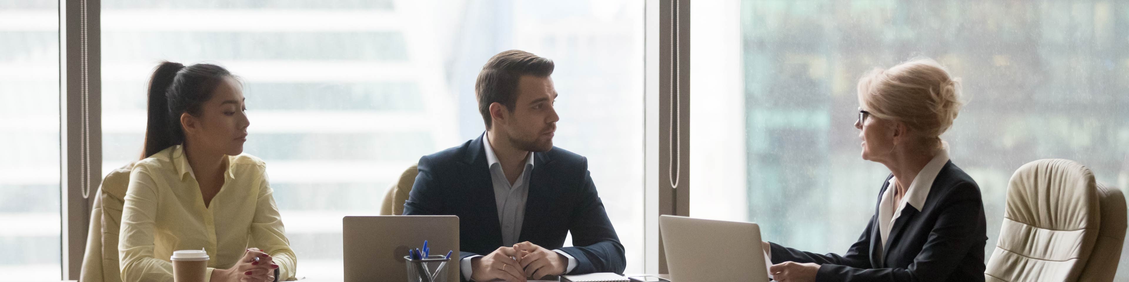 3 businesspeople sitting around a table talking