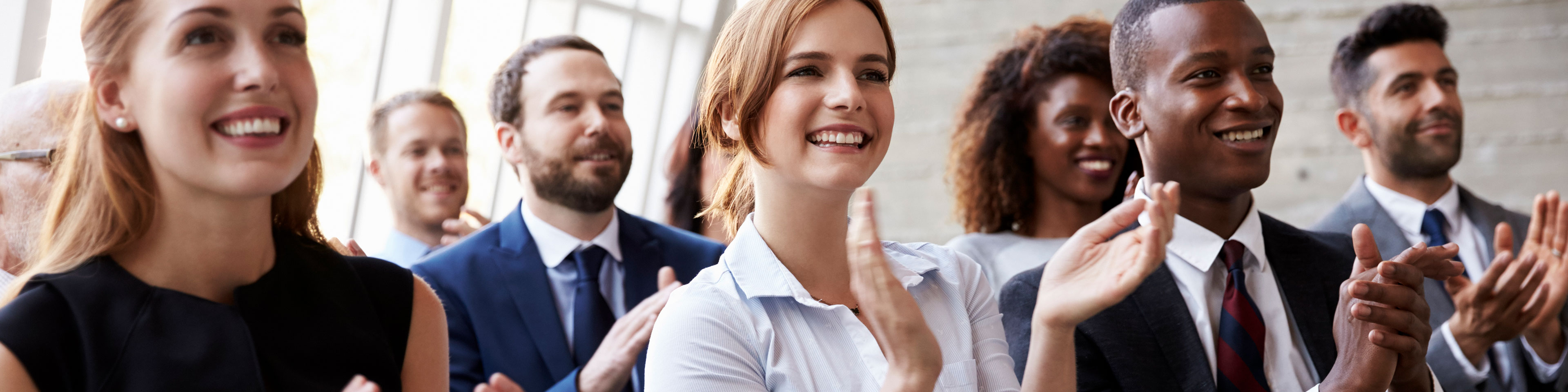 Group of professionals clapping during a presentation.