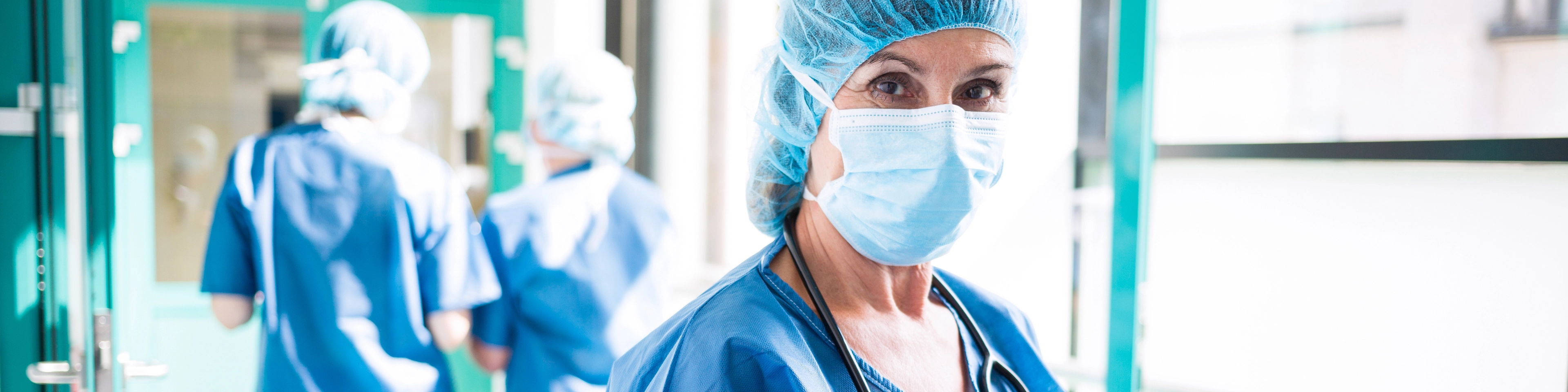 clinician with mask and tablet looking at camera