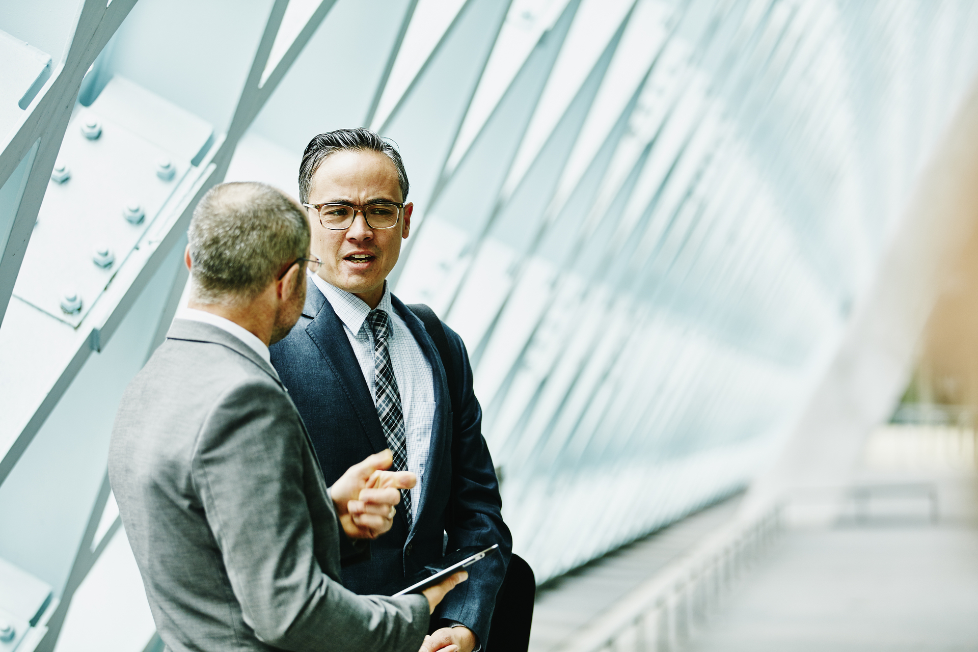 Two businessmen discussing data on digital tablet