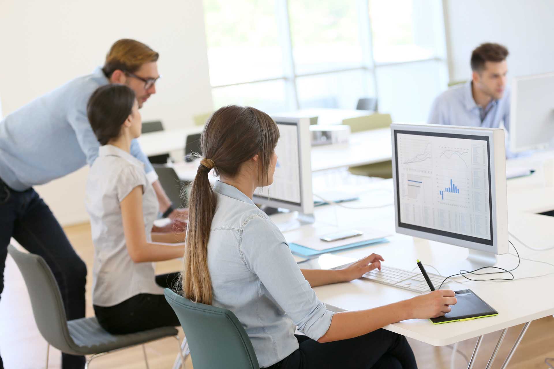 people in an a government agency office looking at computers