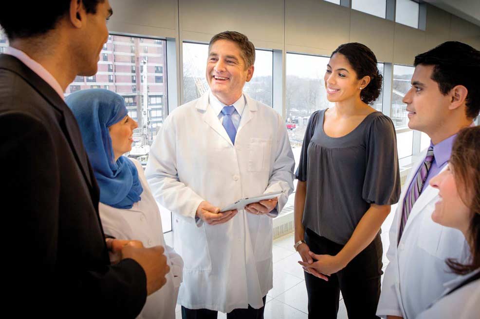 group of doctors and business people talking in hallway