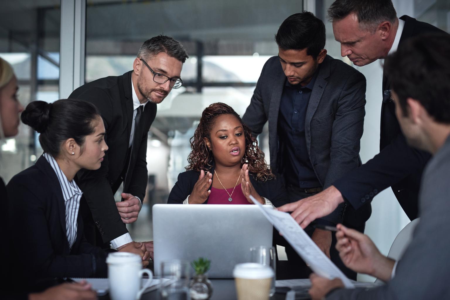 Businessmen and Business woman discussing over the laptop in meeting room