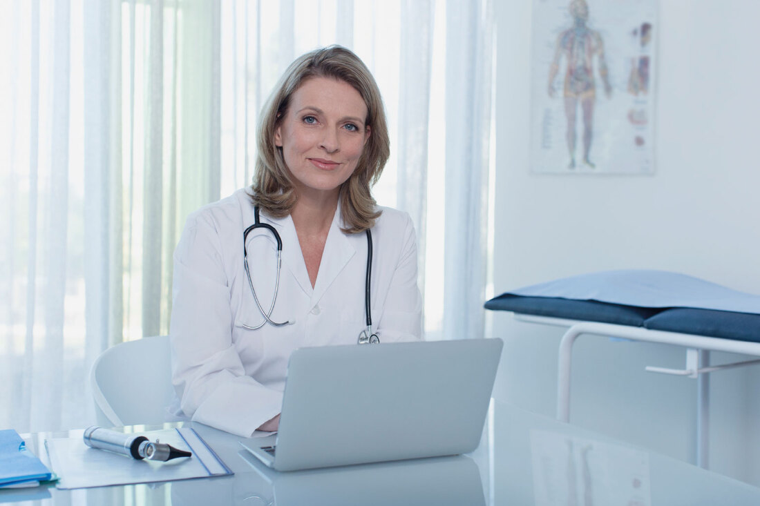 Lekarka czyta na laptopie o kompensacji szkód medycznych