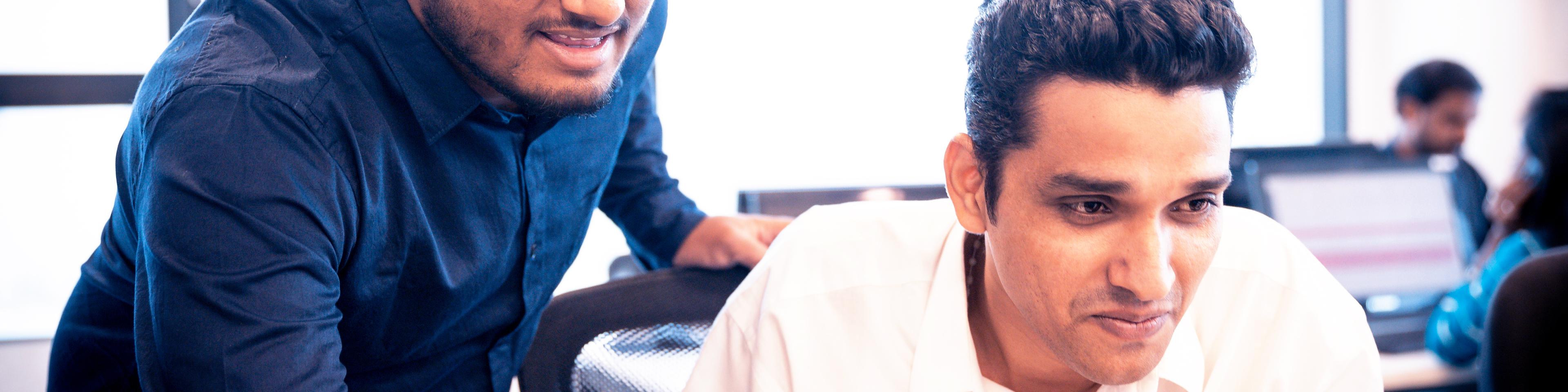 Two Indian employees discussing over a laptop