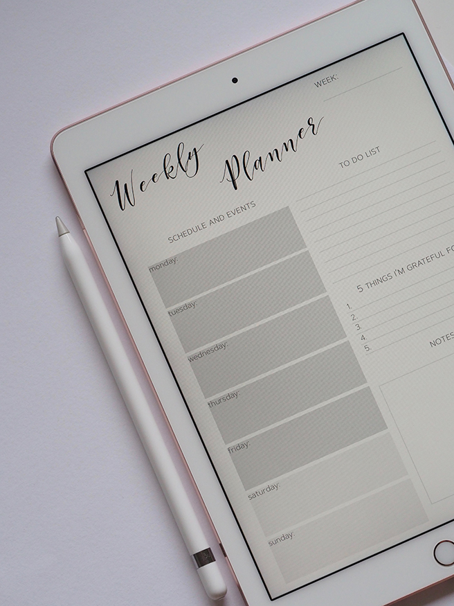 iPad with Apple Pencil attached to side showing a blank weekly planner on the screen