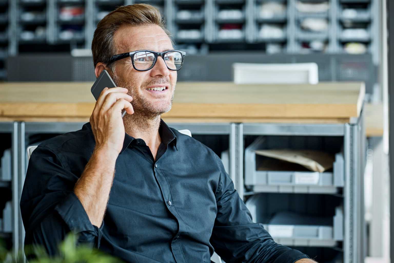 Man on smartphone in storage area