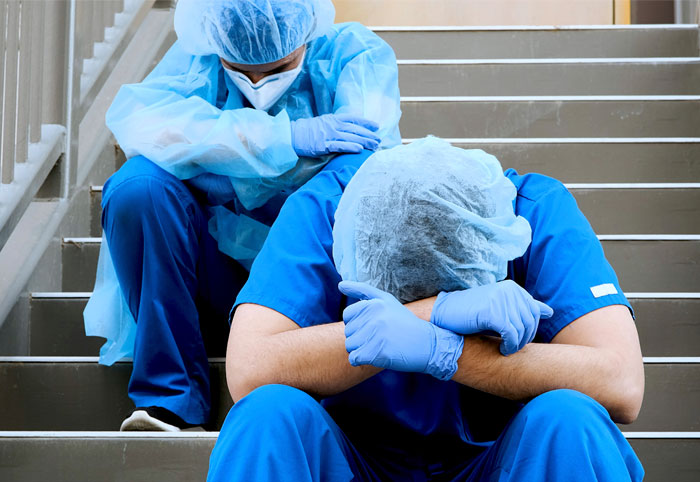 Frustrated healthcare workers sitting on steps 