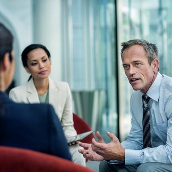 Businessman discussing strategy with female colleagues in office