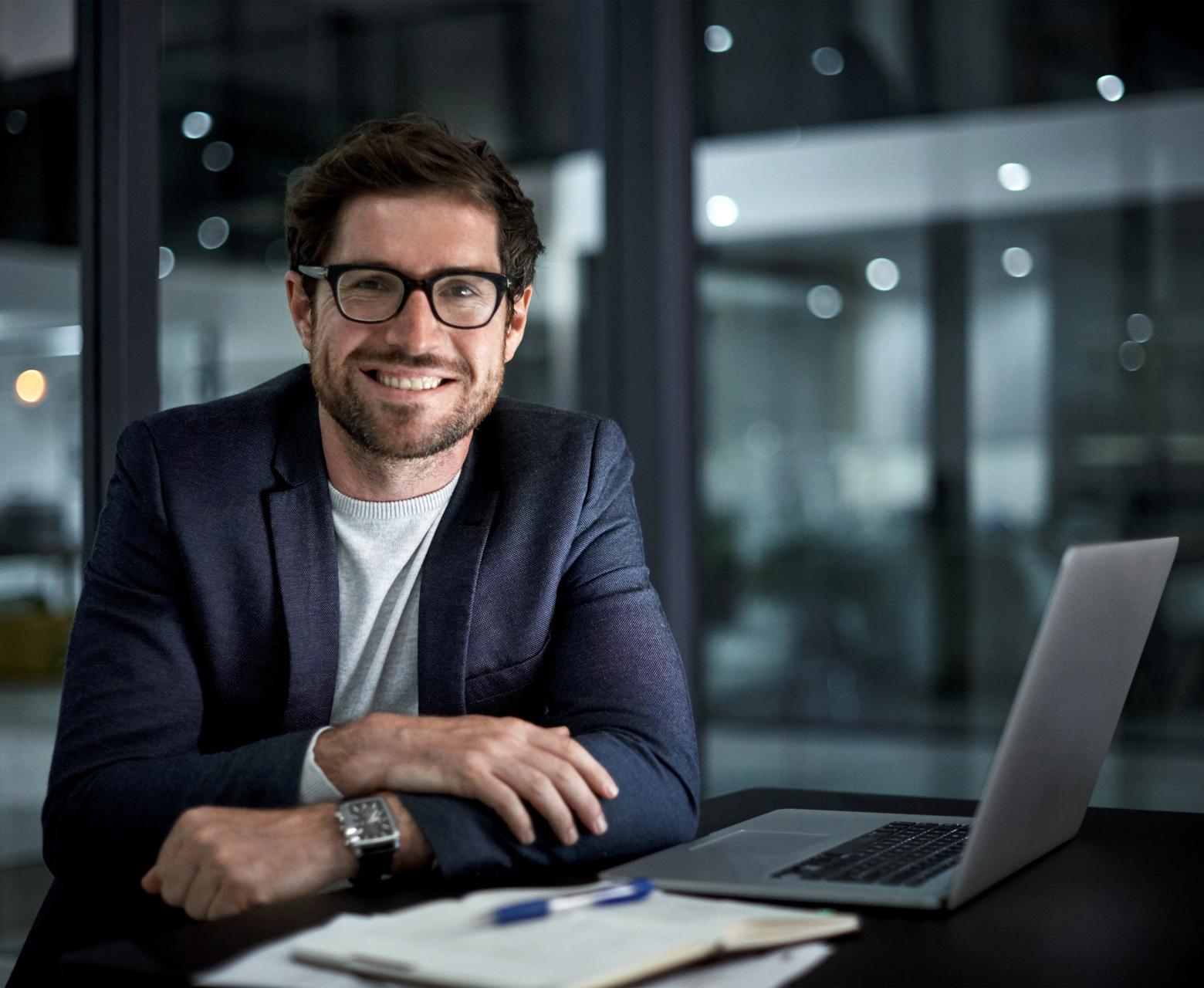 Portrait of a happy young businessman working at his office desk