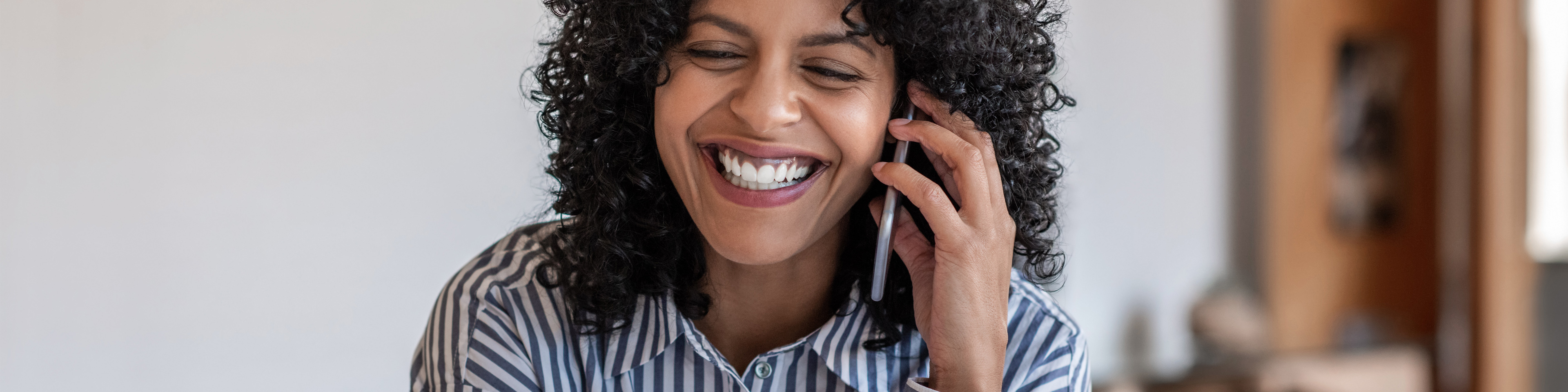 Laughing female entrepreneur talking with a client on cellphone