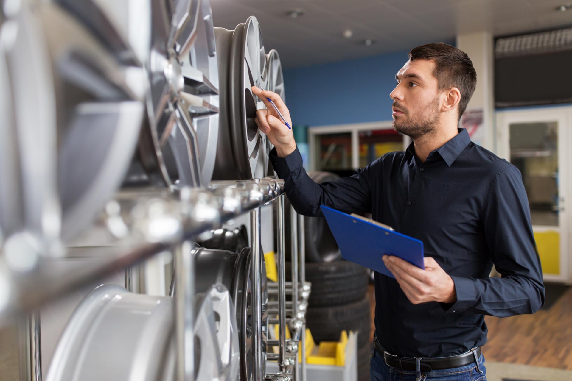 Employee of an S corporation taking stock of car rims