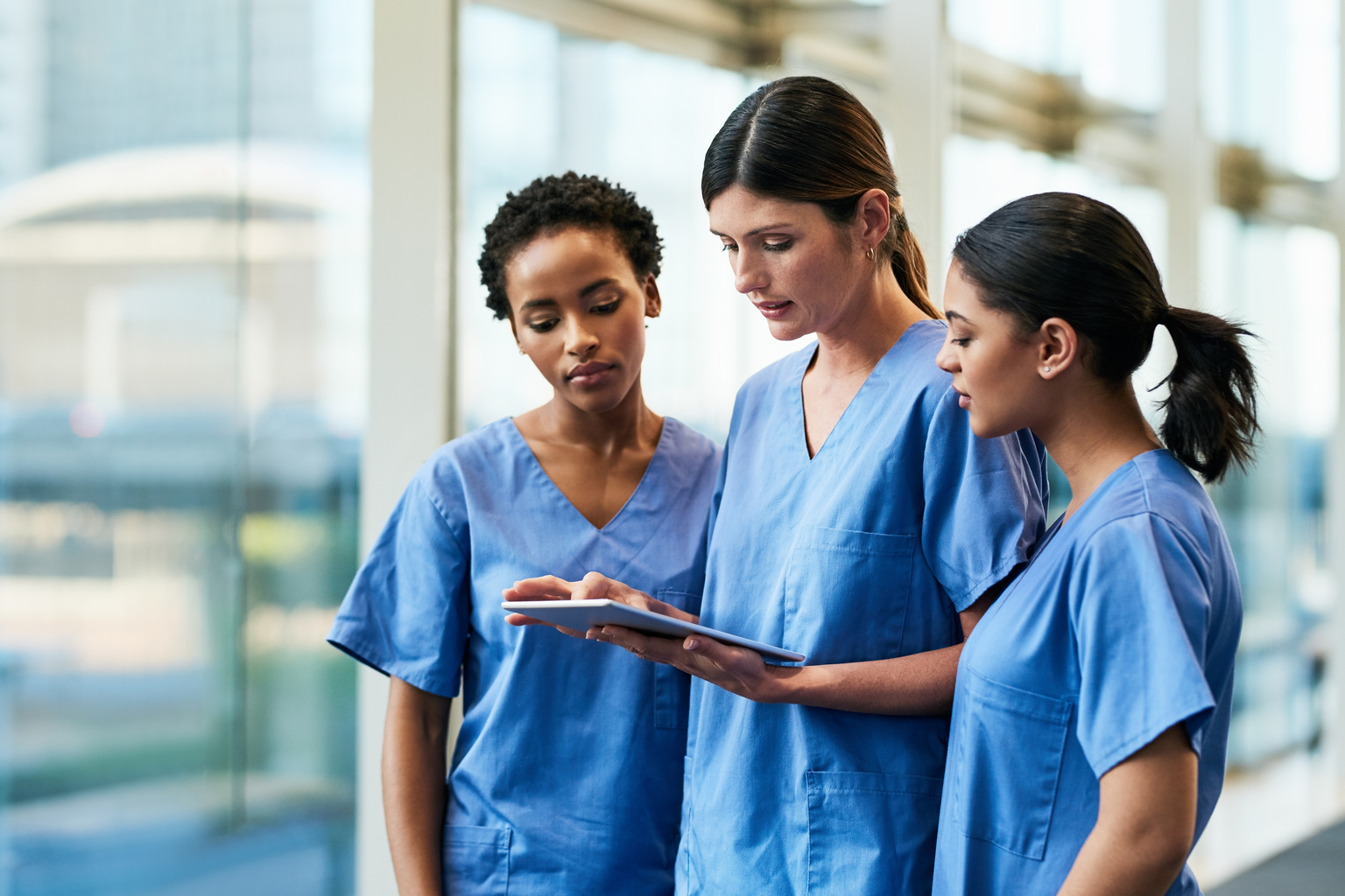 Group of nurses reviewing material on a tablet